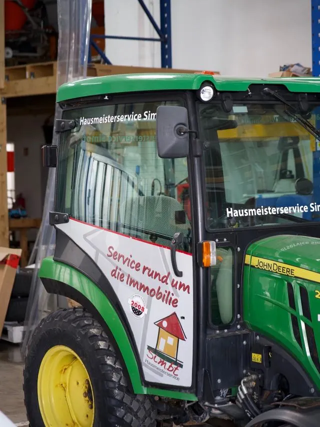 Grüner Kommunaltraktor mit Simbt-Logo und Slogan Service rund um die Immobilie
