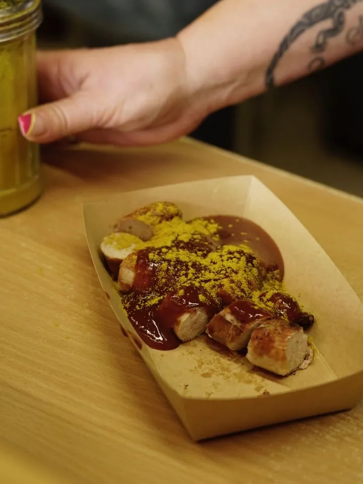 Currywurst von CurryCo mit Currypulver in der Pappschale